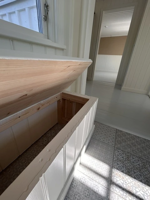 Öppen förvaringsbänk i furu i hall med mönstrat klinkergolv